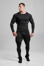 Muscular man in black compression sportswear on gray background Royalty Free Stock Photo