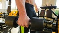 Muscular man bodybuilder holds a dumbbell. Close up