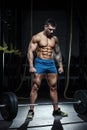 Muscular man bodybuilder prepares for lifting heavy barbell in gym. Fit muscle guy workout with weights and barbell Royalty Free Stock Photo