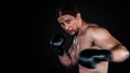 Muscular man boxing with gloves. boxer punching fist movement .  Isolated on black background with copy Space Royalty Free Stock Photo