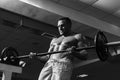 Muscular man doing crossfit. Fit man doing biceps lifting barbell. Young man working out at crossfit gym. Athletic guy Royalty Free Stock Photo