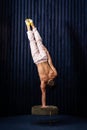 Muscular man doing handstand by one hand at home. Concept of yoga, creativity and healthy lifestyle