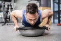 Muscular man doing push up on bosu ball