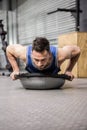 Muscular man doing push up on bosu ball