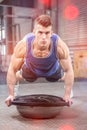 Muscular man doing push up on bosu ball