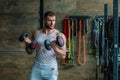 Muscular man doing workout with dumbbells in gym. Handsome man with big muscles posing in the gym. Muscular sportsman Royalty Free Stock Photo