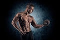 Muscular man with dumbbells on black background