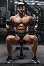 Muscular man with dumbbells workout in gym, strong male naked torso abs
