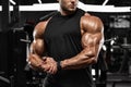 Muscular man in gym, biceps muscles. Strong male