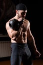 Muscular man in the gym picks up with kettlebell.