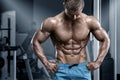 Muscular man in gym, sixpack abs. Strong male nacked torso, working out