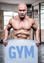 Muscular man holding placard with text gym Royalty Free Stock Photo