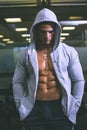 Muscular man in hood jacket at gym