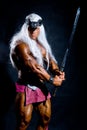 Muscular man in an image of a barbarian with a raised sword. Royalty Free Stock Photo