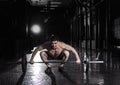 Muscular man lifting a barbell in crossfit gym.