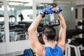 Muscular man lifting dumbbell while sitting on bench Royalty Free Stock Photo