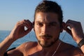 Muscular man listening to music on headphones at beach Royalty Free Stock Photo