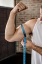 Muscular man measuring biceps Royalty Free Stock Photo