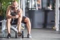 Muscular man practicing with dumbbells in fitness gym