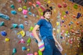 Muscular man practicing rock-climbing on a rock wall indoors Royalty Free Stock Photo