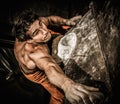 Muscular man practicing rock-climbing