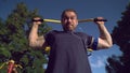 A muscular man is pulling himself up in the park.