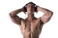 Muscular man shirtless, listening to music on headphones Royalty Free Stock Photo