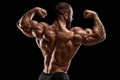 Muscular man showing back muscles, isolated on black background. Strong male rear view Royalty Free Stock Photo