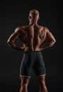 Muscular man showing back muscles, isolated on black background. Strong male rear view Royalty Free Stock Photo