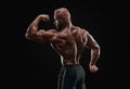 Muscular man showing back muscles, isolated on black background. Strong male rear view Royalty Free Stock Photo