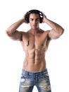 Muscular man standing, listening to music on headphones Royalty Free Stock Photo