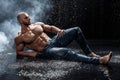 Muscular man under the rain in studio. Sexy male in water drops, abs Royalty Free Stock Photo