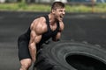Muscular man working out flipping tire, outdoor. Strong male crossfit training Royalty Free Stock Photo