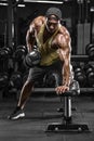 Muscular man working out in gym doing exercises for back. Single Arm Dumbbell Row Royalty Free Stock Photo