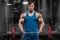 Muscular man working out in gym doing exercises with barbell at biceps, strong male Royalty Free Stock Photo