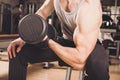 Muscular man working out in gym doing exercises with dumbbells at biceps Royalty Free Stock Photo