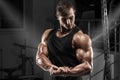 Muscular man working out in gym. Strong male showing muscles biceps