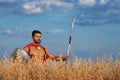 Muscular medieval warrior standing in the field