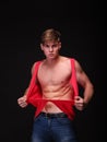 handsome young man tearing shirt off on a black background. Fitness and workout concept. Royalty Free Stock Photo