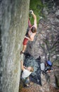 Muscular rock climber climbs on overhanging cliff