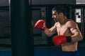 Male boxer in red gloves doing cardio boxing workout with punching bag Royalty Free Stock Photo