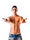 Muscular shirtless man deciding between healthy fruit and unhealthy cookies Royalty Free Stock Photo