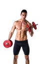 Muscular shirtless young man exercising biceps with dumbbells Royalty Free Stock Photo