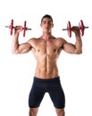 Muscular shirtless young man exercising shoulders with dumbbells Royalty Free Stock Photo