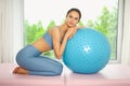 Muscular slim attractive female, flat belly perfect body. Beautiful fit woman doing yoga exercises with fitness pilates blue ball Royalty Free Stock Photo