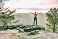 Muscular sports man shirtless standing on rock against