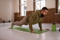 Muscular sportsman doing exercises alone in gym. Young handsome sports guy doing push ups exercise in empty gym with Royalty Free Stock Photo