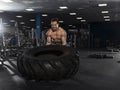 Muscular,Strong bodybuilder pushing tire in modern fitness cente