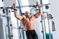 Muscular strong man working out at a gym.