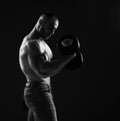 Muscular strong men, bodybuilder is working out, lifting dumbbells weights, does exercises for biceps looking at it Royalty Free Stock Photo